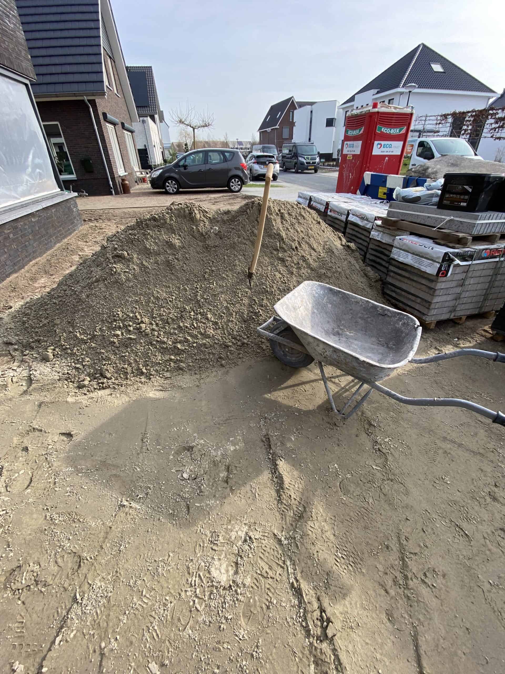 Zand scheppen voor stoep van de buren te fixen